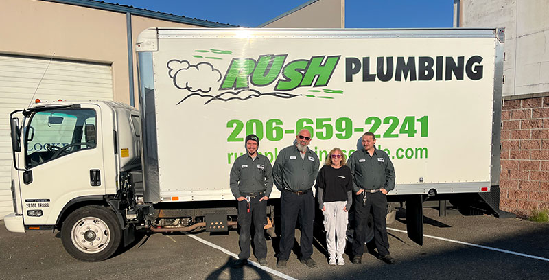 4 people from Rush Plumbing standing in front of a Rush Plumbing truck, who are Algona's Top Choice for Plumbing Services